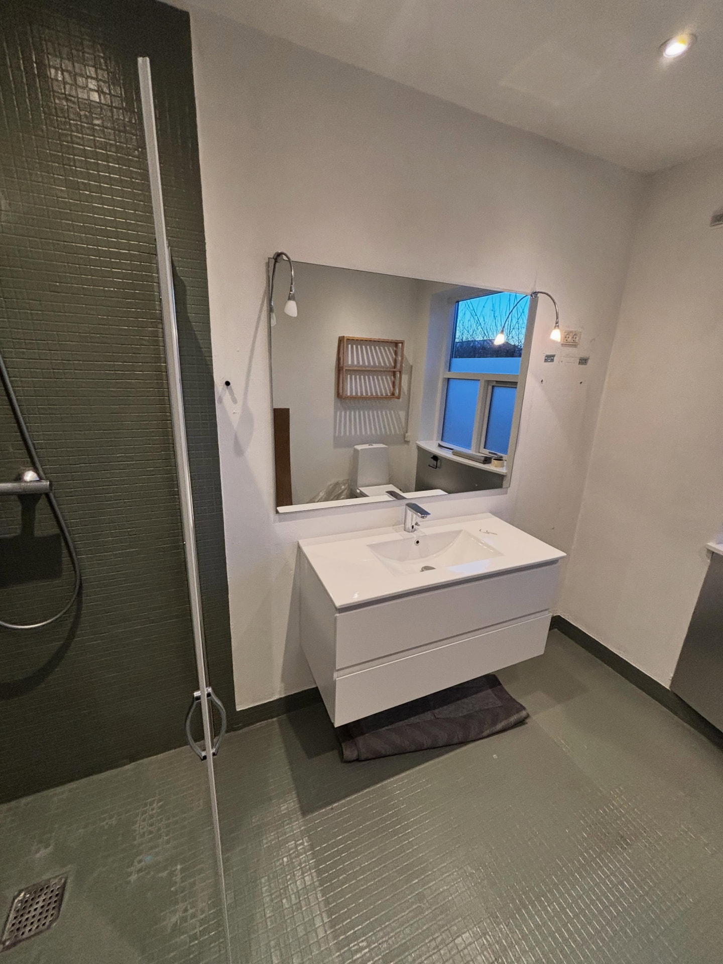 Gammel vaskeplads med spejl og hvid vaskeskab før renovering
