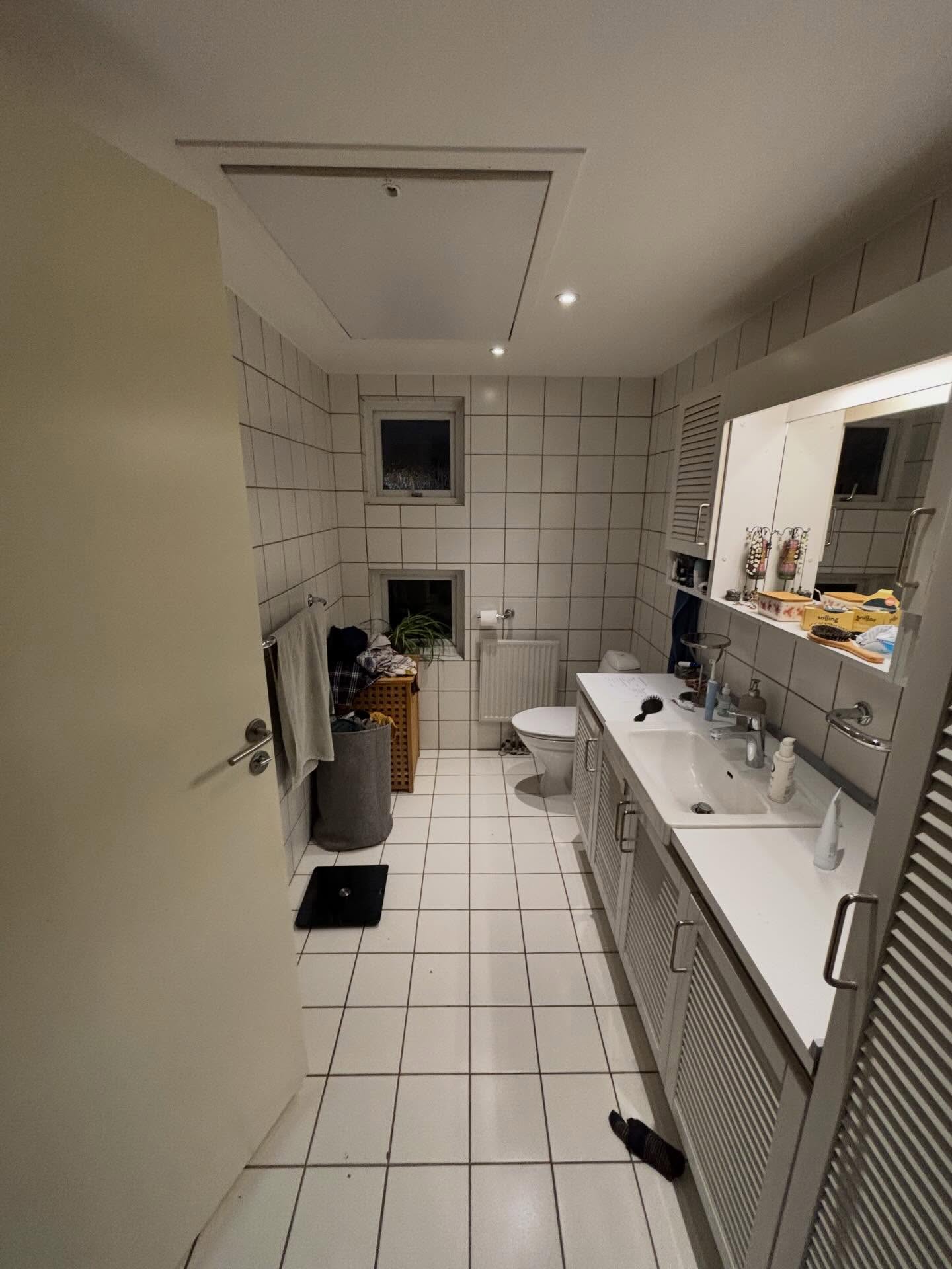 Det gamle badeværelse i Valby med hvide fliser og hvidt vaskeskab