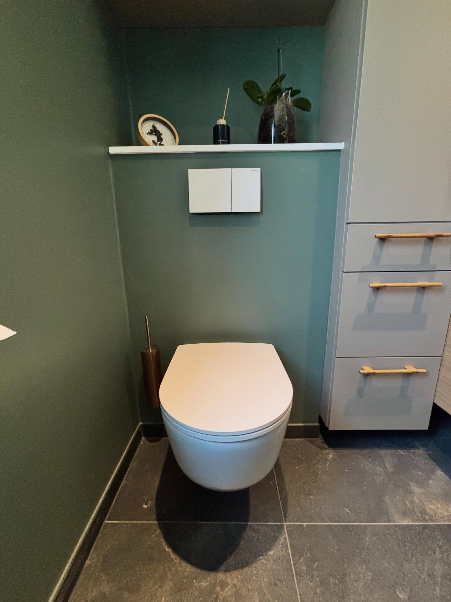 Væghængt toilet med indbygget cisterne og hvidt betjeningstryk