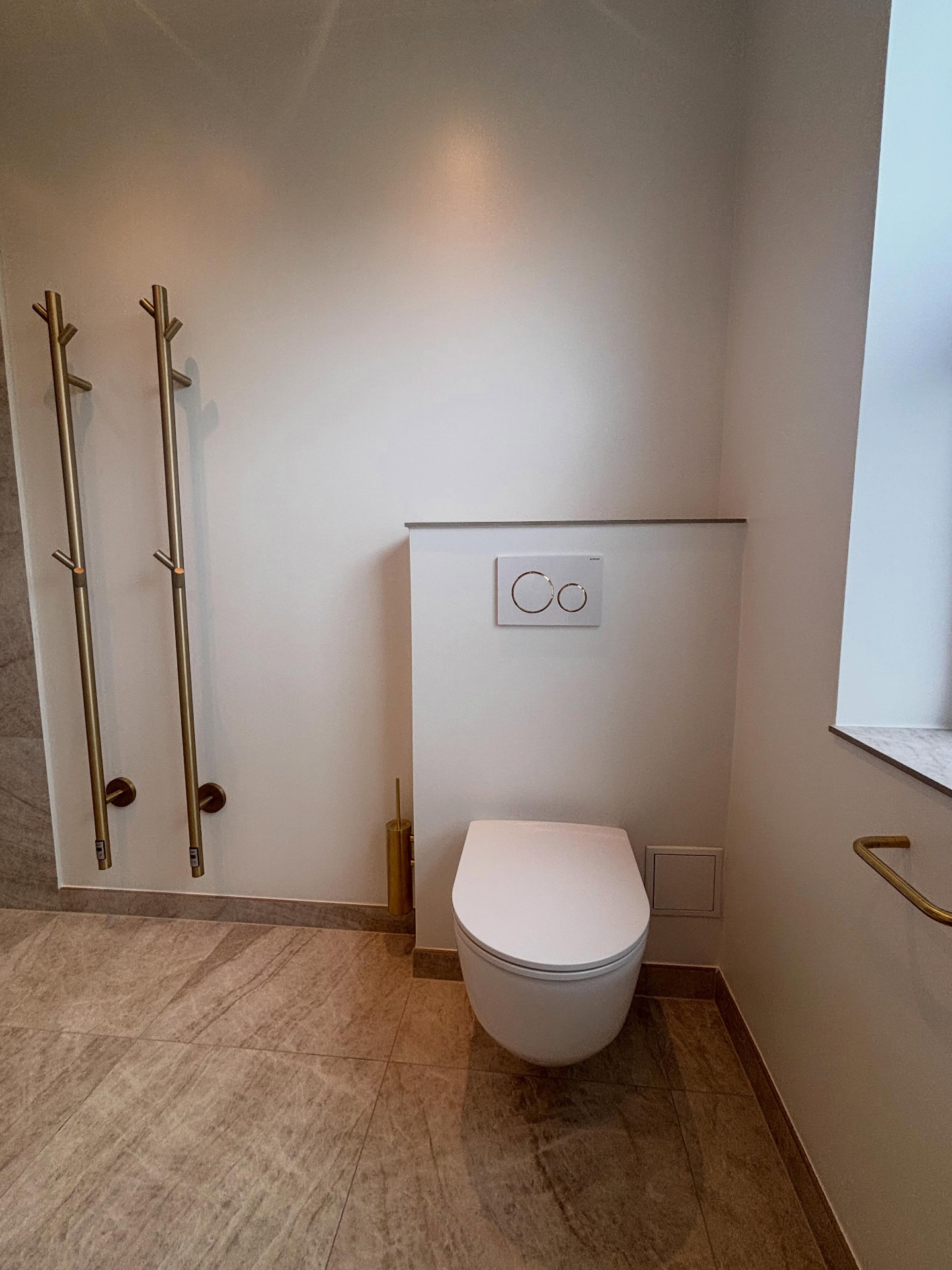 Væghængt toilet med indbygget cisterne og hvidt betjeningstryk
